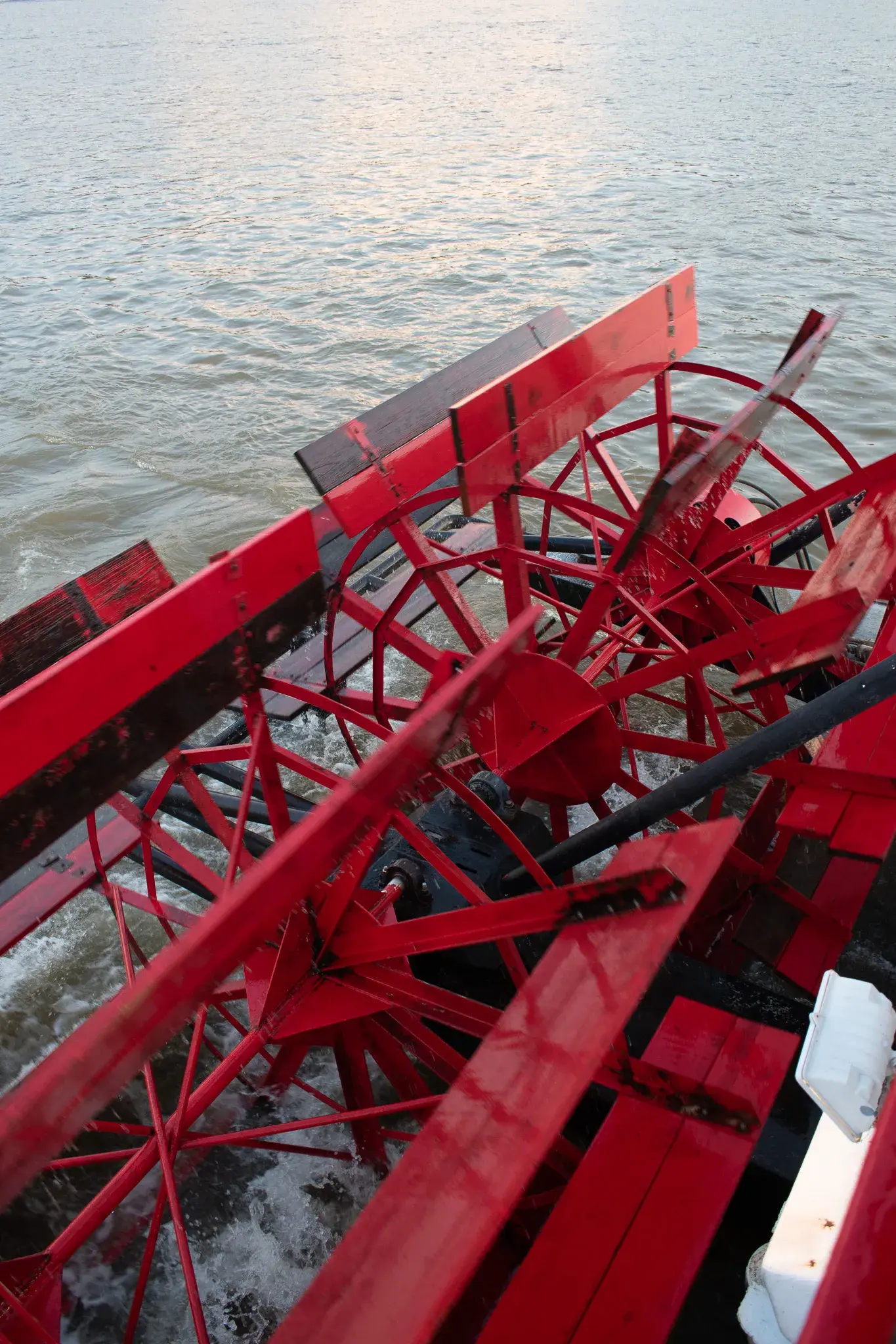 The red paddlewheel of the Spirit of Cincinnati churning the Ohio River